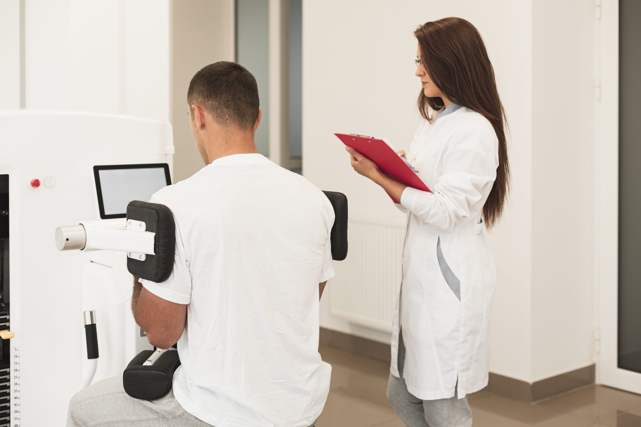 back-view-patient-using-medical-device-supervised-by-doctor Patient using a medical device while supervised by a doctor