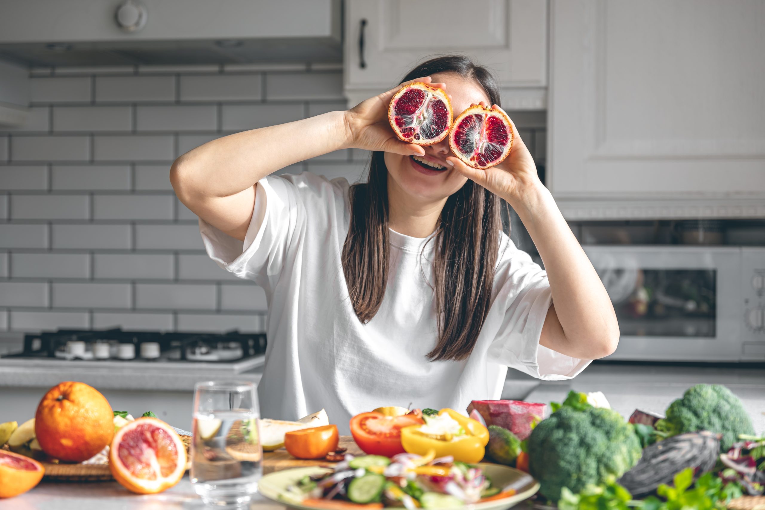 Woman holding orange halves, a vitamin C food that supports collagen and skin elasticity