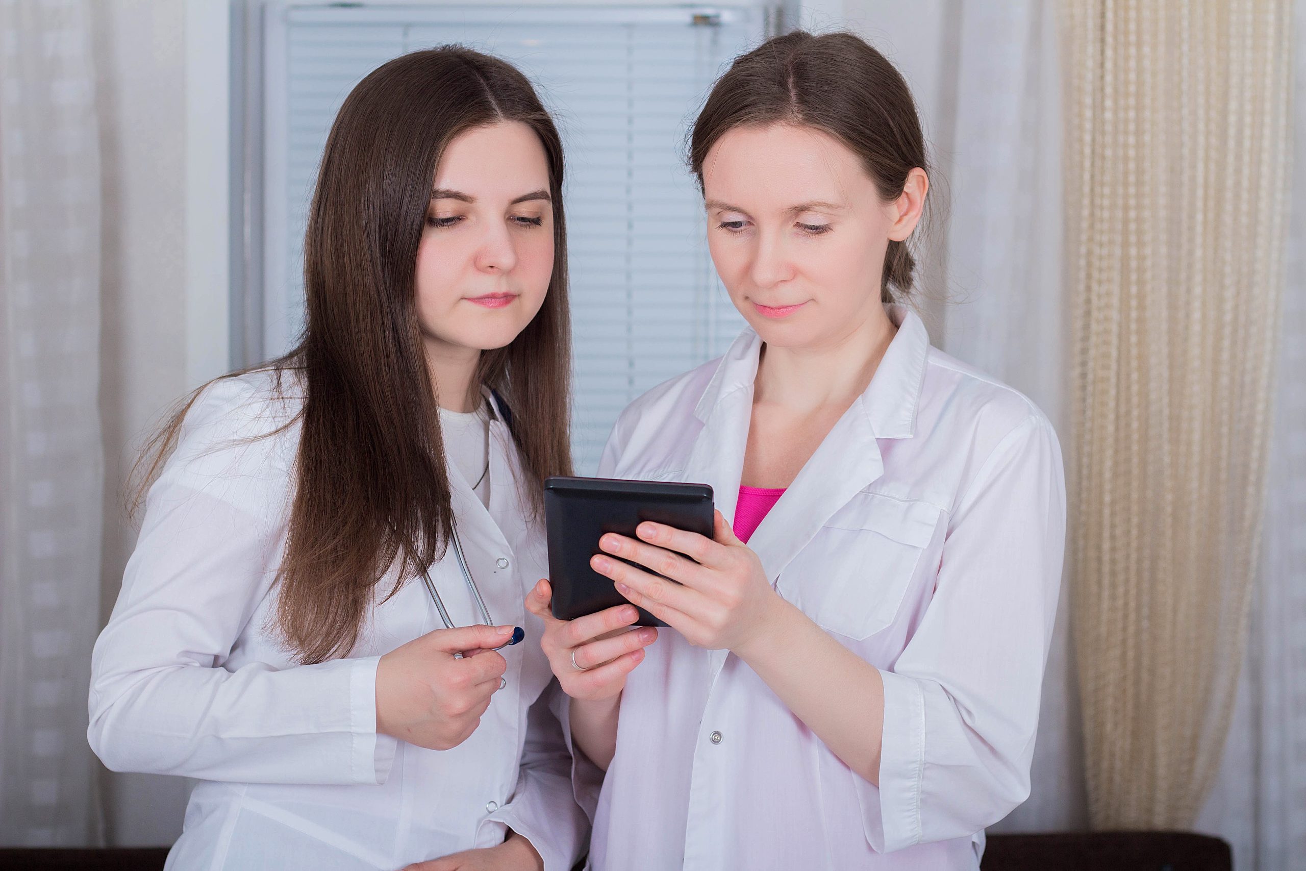 Two clinicians reviewing a patient anti-aging and wellness plan on a tablet